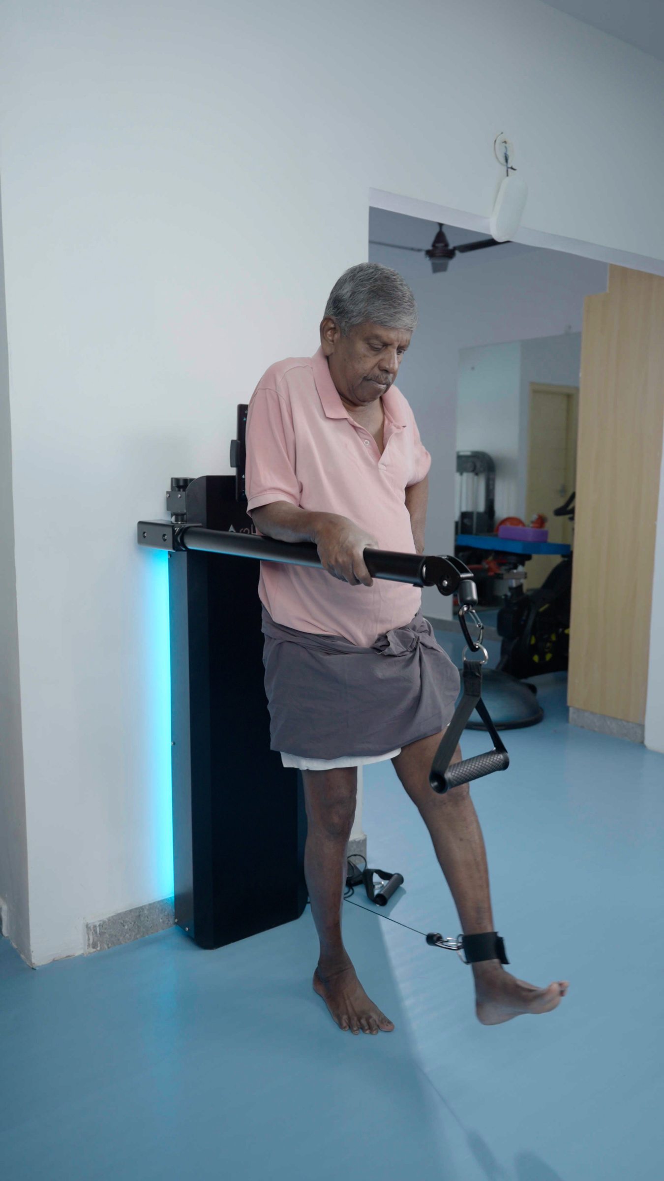 A patient doing standing leg work using an ankle strap on Aroleap
